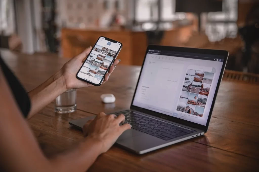 A person sitting at a desk and reading about adaptive vs. responsive design on their laptop